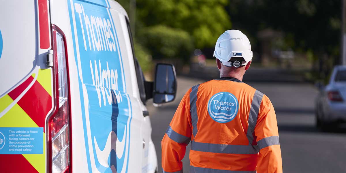 An engineer walking next to a Thames Water van