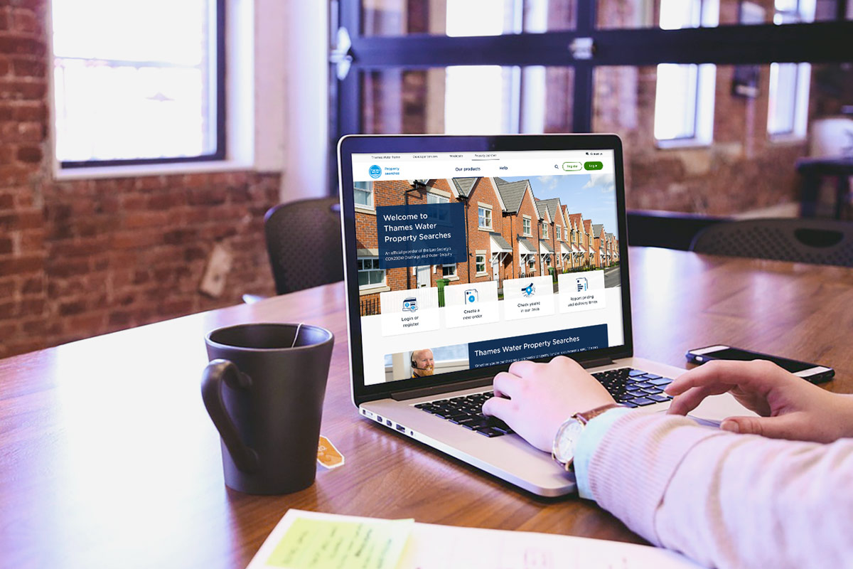 A person using a laptop with the Property Searches homepage 