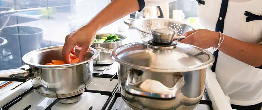 Lady putting food into a silver pan