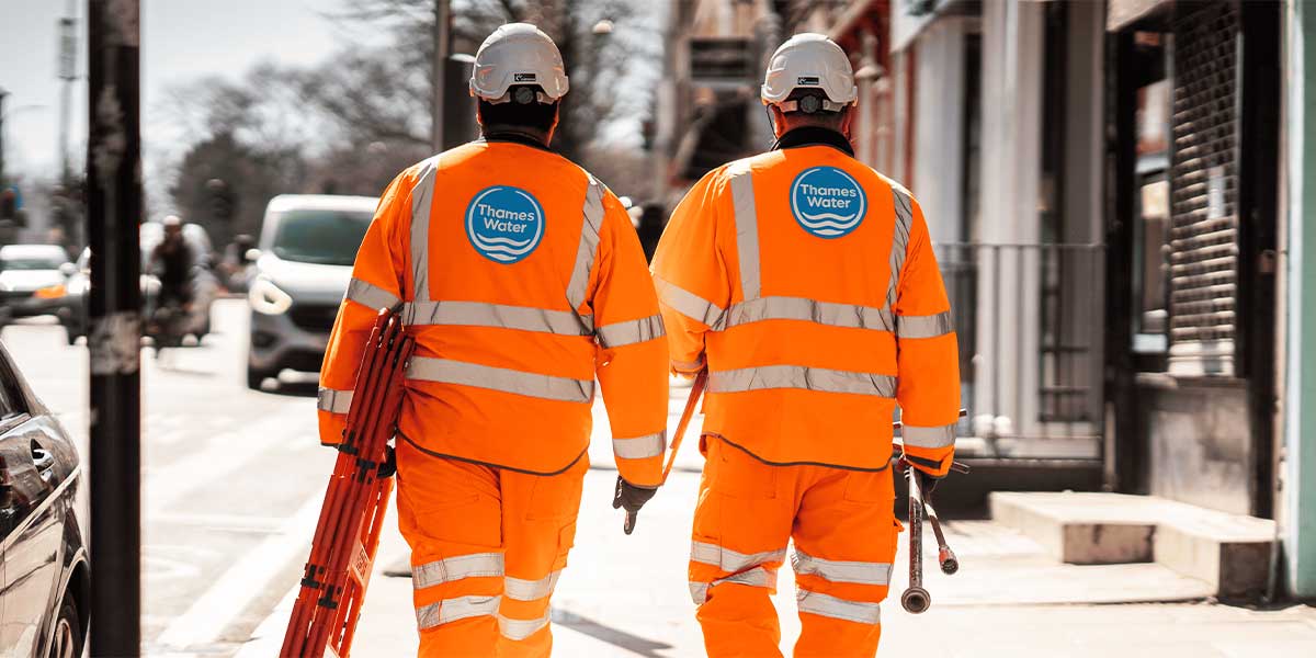 Two NSTs walking on a pavement to set up a work site