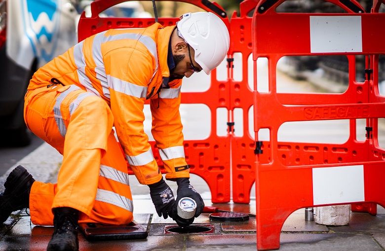 Thames worker checking meter on street