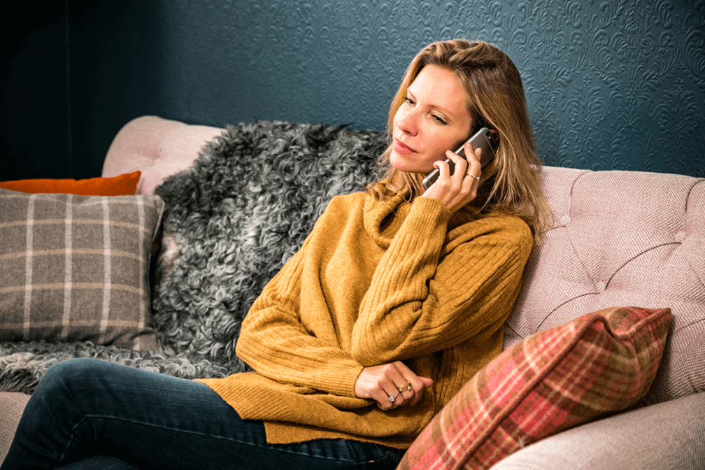 A lady sitting on the sofa on the phone